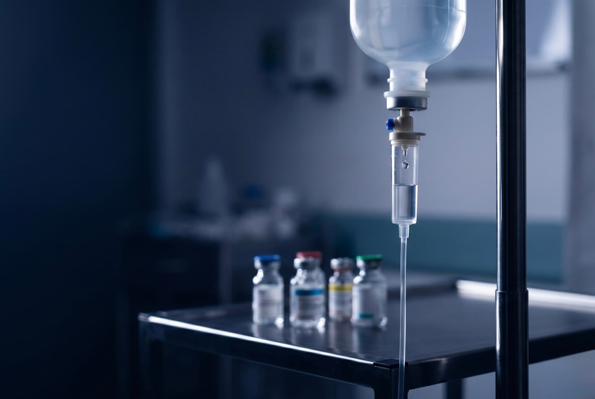 Bolsa de suero intravenoso colgada junto a viales de electrolitos