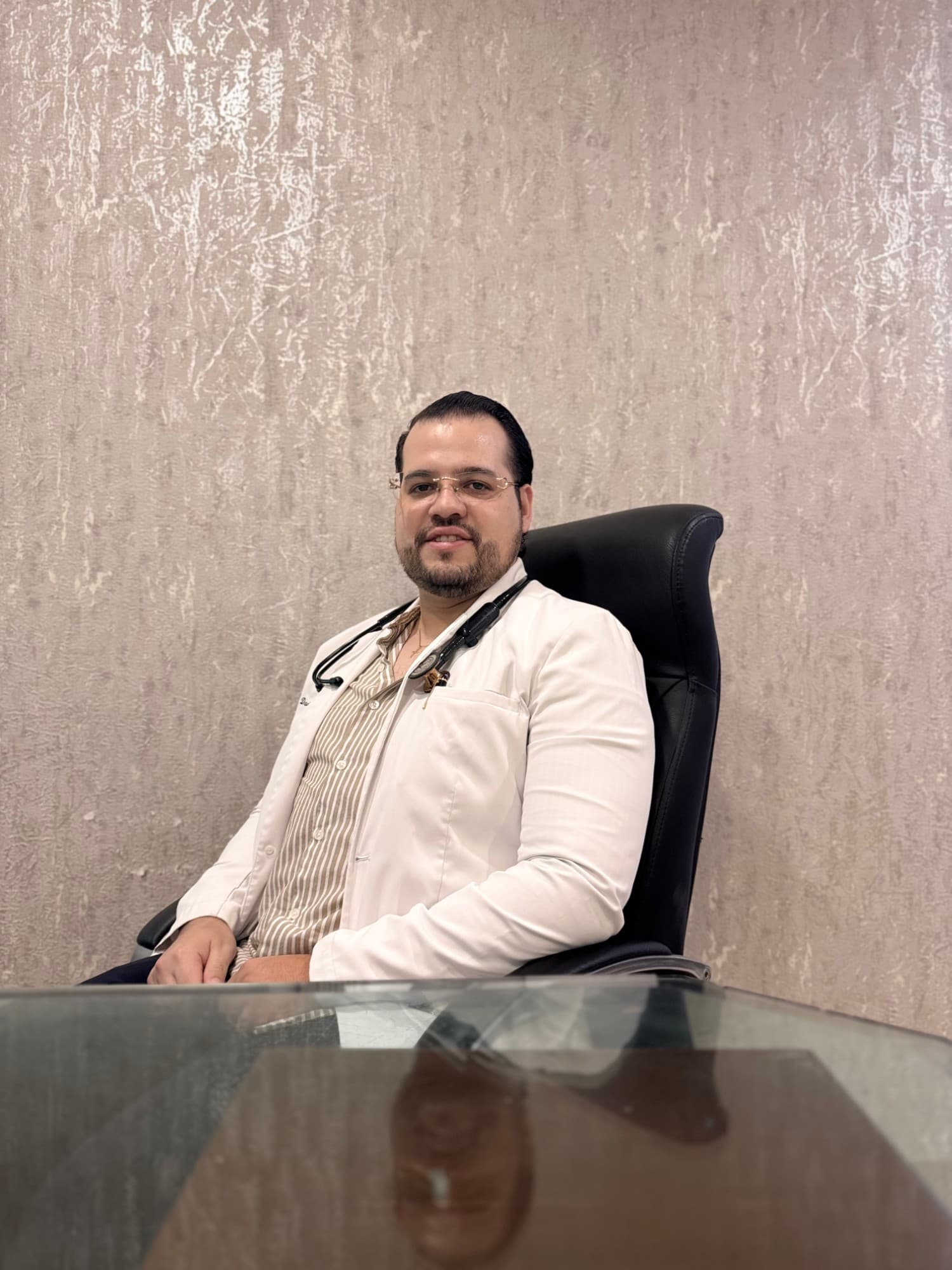 Dr. David Rojas, médico internista — retrato en consultorio con bata blanca y estetoscopio