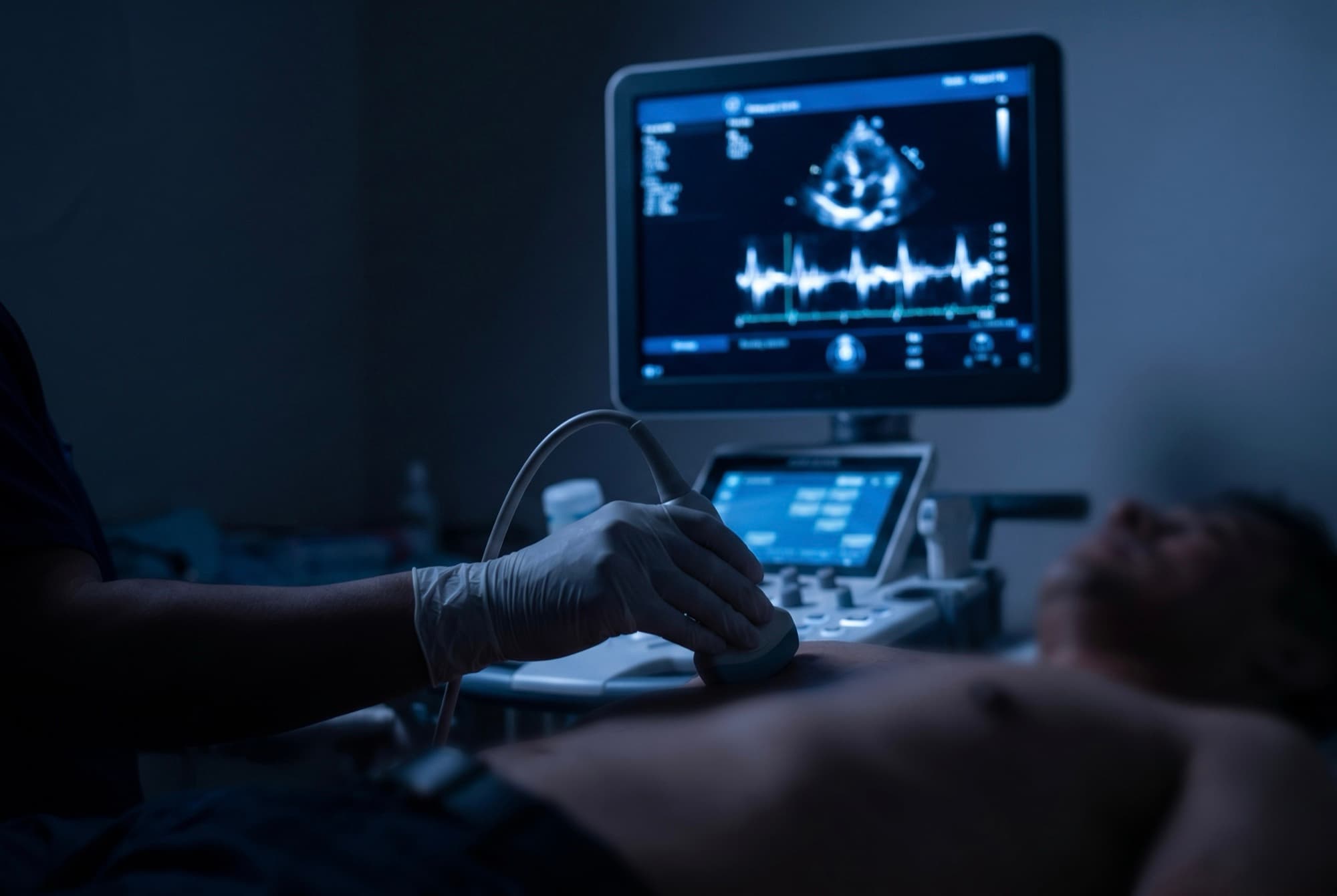 Ecocardiograma en proceso: transductor sobre el torax y eco cardiaco en pantalla